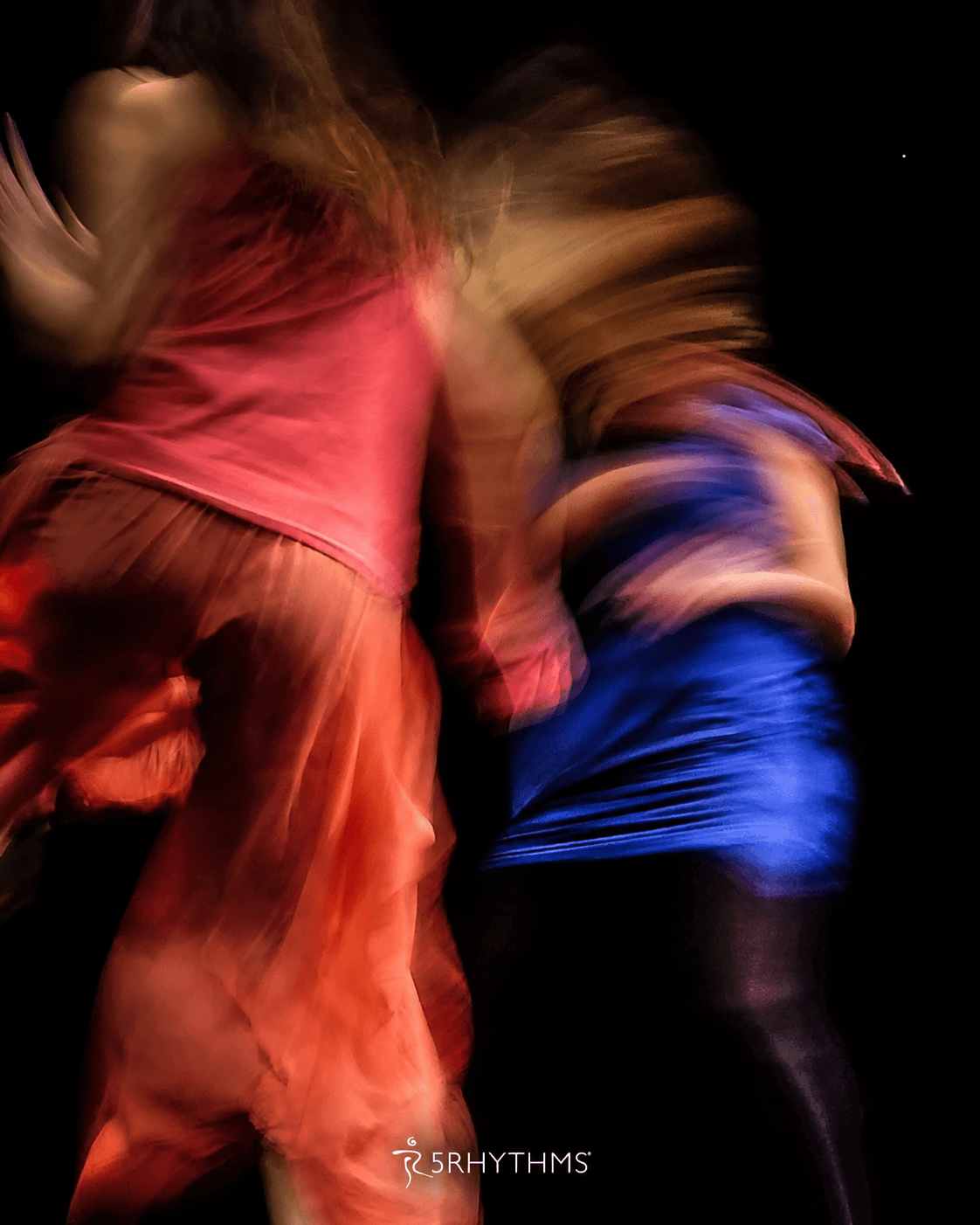 Two dancers mid-movement in a 5Rhythms class
